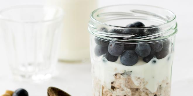 a jar of oats, blueberries, and milk